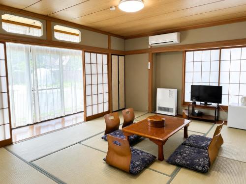 a living room with a table and chairs and a television at Yamanaka Lake Ryozan in Yamanakako