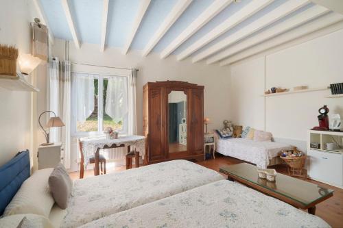 a living room with two beds and a table at Le Bois Du Mas in Saint-Aulaye
