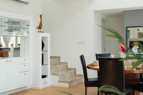 a dining room with a staircase and a table at 3BR Panoramic Sea View Villa with Private Pool by Cyprus Horizons in Pissouri