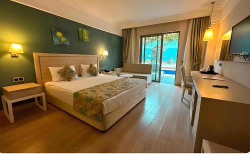 a hotel room with a bed and a desk and a room at Linda Sunny Beach Hotel & Spa-Ultra All Inclusive in Side