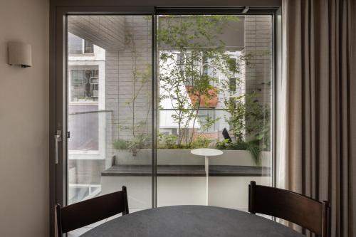 a table and chairs in a room with a window at Long Weekend Haus in Seoul