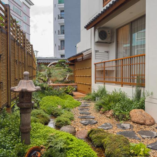 a garden with a fire hydrant in front of a building at Tatami Hotel Phuket in Ban Ket Ho