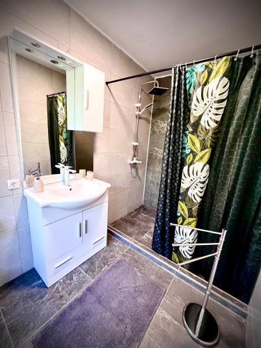a bathroom with a sink and a shower curtain at House by the River in Plitvica Selo