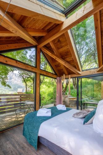 two beds in a room with large windows at Les chalets d'Éléna in Saint-Jean-Saint-Nicolas