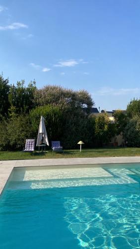 a swimming pool with a tent and two lawn chairs at Pioppi Neri R&B in Felino