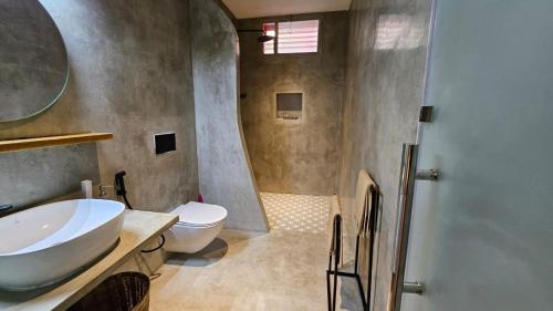 a bathroom with a sink and a toilet at Le Jardin Suffren LOFT in Jāmb