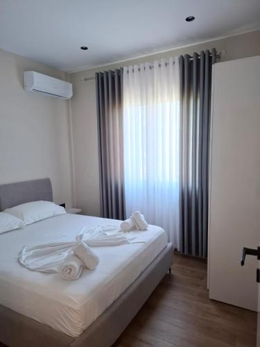 a bedroom with a bed with towels on it at Vila Familjare Vlore in Vlorë
