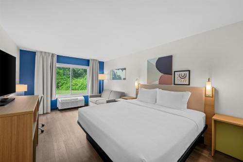 a hotel room with a large bed and a desk at Spark by Hilton Brunswick in Brunswick