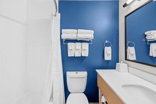 a blue bathroom with a toilet and a sink at Spark by Hilton Brunswick in Brunswick