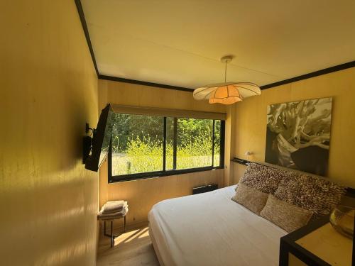 a bedroom with a large bed and a window at Het Kleine Genoegen in Heelweg