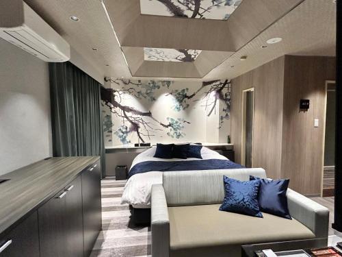 a bedroom with a bed and a couch in it at ホテル侘 in Himeji