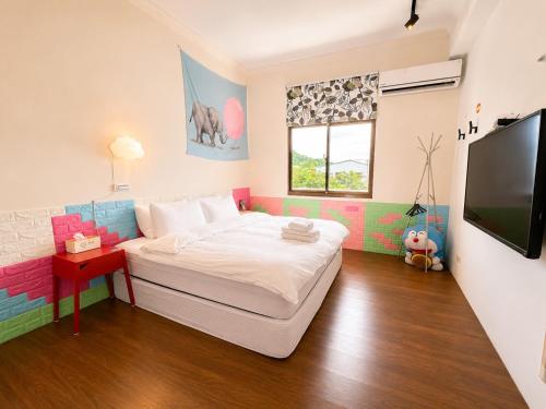 a bedroom with a bed and a flat screen tv at 台東醇旅旅宿-民宿編號1417 in Lijia