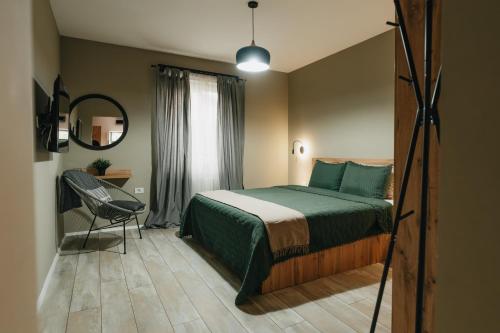 a bedroom with a bed and a chair and a mirror at Apartments Vidanovic in Ohrid