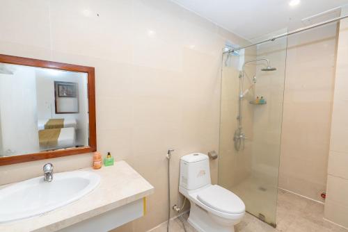 a bathroom with a toilet and a sink and a shower at Catinal Hotel in Danang