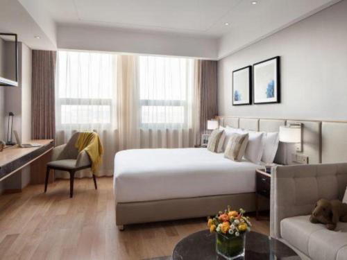 a hotel room with a bed and a couch at Shama Daqing Heilongjiang in Daqing