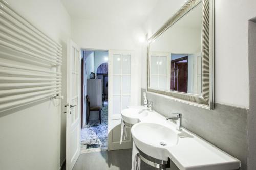 Un baño blanco con dos lavabos y un espejo. en Villa Acacia, en Florencia