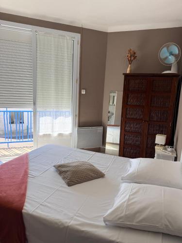 a large white bed in a bedroom with a window at Hotel le Bon Soleil in Les Sables-d'Olonne