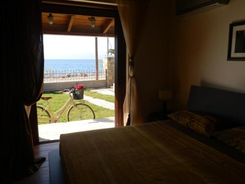 a bedroom with a bed and a view of the ocean at Villa Dimitra in Erateini