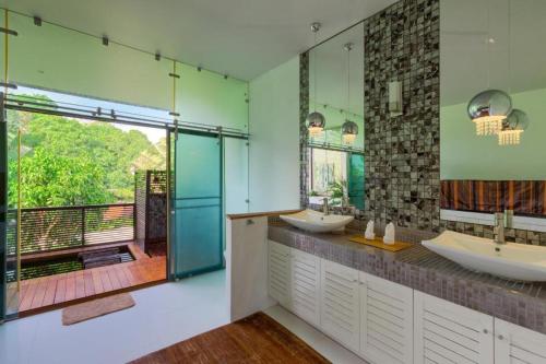 a bathroom with two sinks and a large window at Villa Oxavia in Rawai Beach