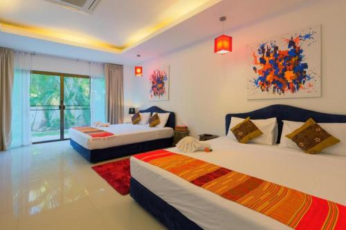 a hotel room with two beds and a window at Villa Oxavia in Rawai Beach