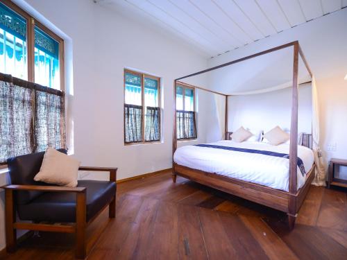 a bedroom with a canopy bed and a chair at Neighbor Phuthon in Bangkok