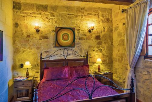 a bedroom with a bed in a stone wall at Strawberry Hills in Żejtun