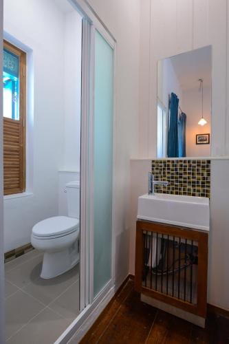 a bathroom with a toilet and a sink and a mirror at Neighbor Phuthon in Bangkok