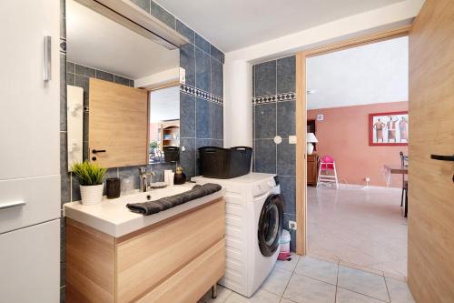 a bathroom with a washer and dryer in a room at Appartement Type F4 in Maurens