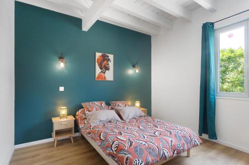 a bedroom with a bed and a blue wall at Maison Mendi Borda Pays Basque in Larribar-Sorhapuru