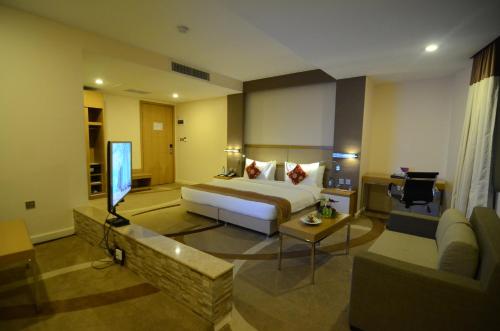 a hotel room with a bed and a television at PrideInn Azure Hotel Nairobi Westlands in Nairobi