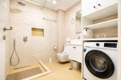 a bathroom with a washing machine and a shower at Oryn Suites in Tirana