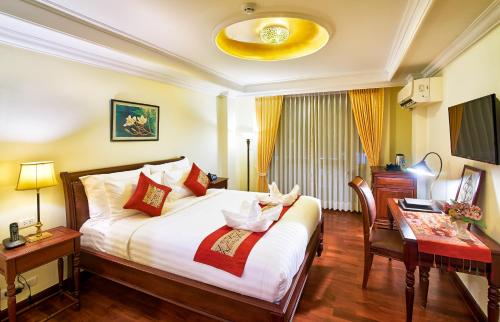 a hotel room with a bed and a desk at Phasouk Vien Chantra Hotel in Vientiane