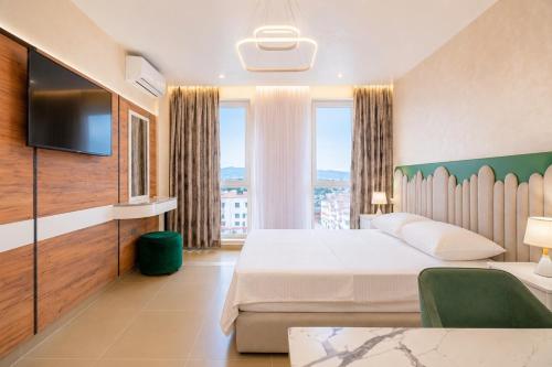 a hotel room with a bed and a tv at Oryn Suites in Tirana
