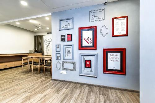 a wall with pictures on it with a table and chairs at Super Hotel O THE FERN SUITES in Hyderabad
