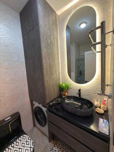 a bathroom with a black sink and a mirror at Чарвак Дарвозаси in Chorwoq