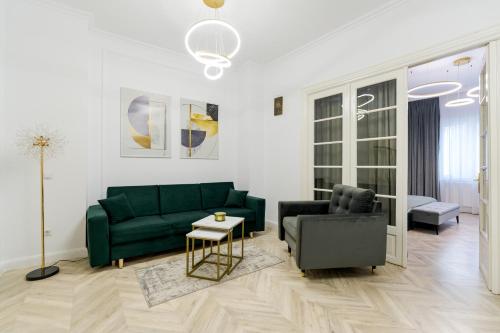 a living room with a green couch and a chair at Downtown Bucharest Villa Private Garden & Garage for Parking in Bucharest