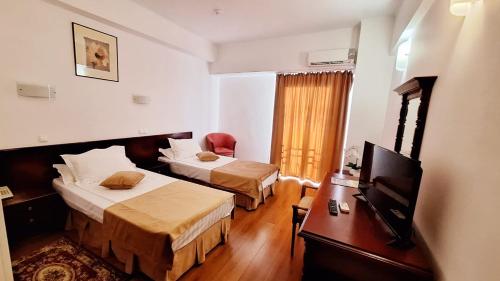 a hotel room with two beds and a television at Hotel Europa in Ploieşti