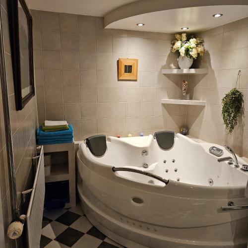 a tub in a bathroom with a tiled floor at Centrala Tanumshede in Tanumshede