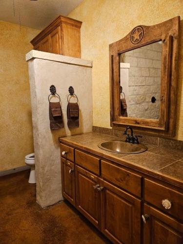 a bathroom with a sink and a mirror at Breezy Hills Cottages - Moonlight Cottage in Fredericksburg
