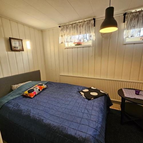 a bedroom with a bed with a blue comforter at Centrala Tanumshede in Tanumshede