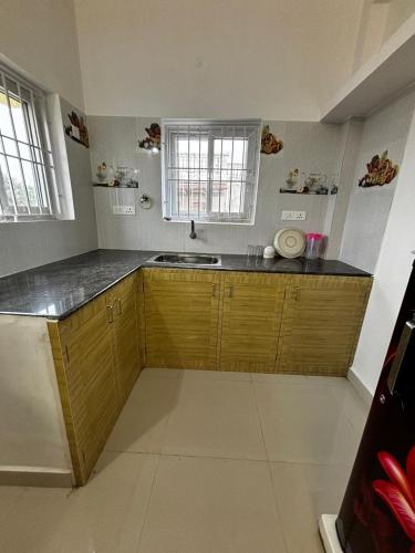 a kitchen with wooden cabinets and a sink at Dreamy beach villa in Pondicherry