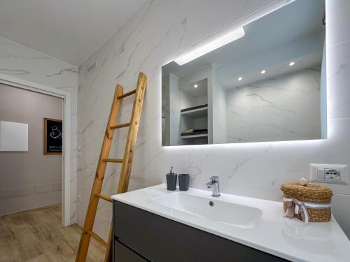 a white bathroom with a sink and a mirror at Mamma Oca in Esanatoglia