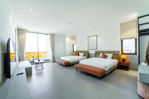 a hotel room with two beds and a television at Lé Blend Residence in Krong Poi Pet