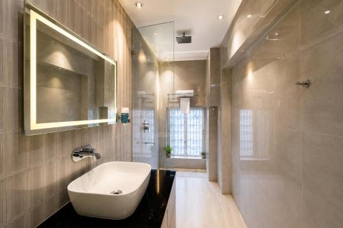 a bathroom with a white sink and a mirror at The Vacation Villa Agra A Boutique Hotel Near Taj Mahal in Agra