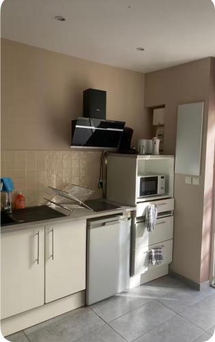 a kitchen with white cabinets and a microwave at Aprile in Palavas-les-Flots