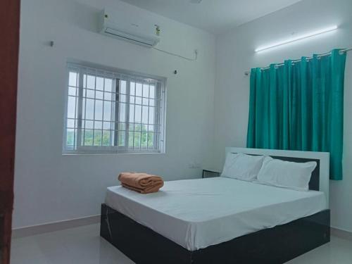 a bedroom with a bed with a green curtain at Dreamy beach villa in Pondicherry