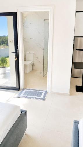a bedroom with a glass door leading to a bathroom at Rajan apartement in Piqeras