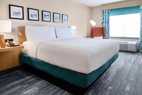 a hotel room with a large bed and a window at Hilton Garden Inn Sioux Falls South in Sioux Falls