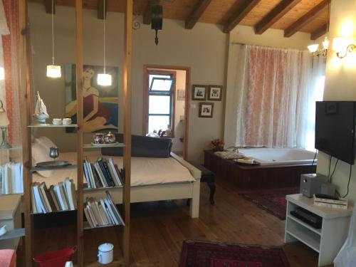 a living room with a bed and a bath tub at Betzel Ha'Ella in Kahal