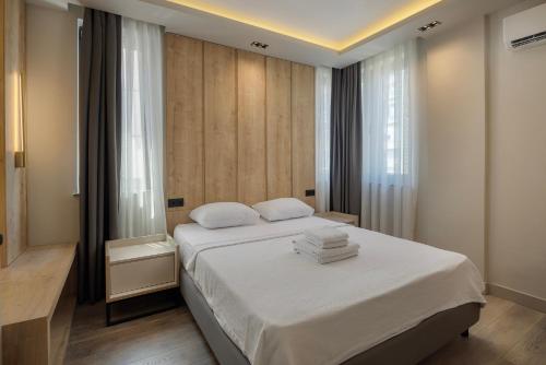 ein Schlafzimmer mit einem Bett mit weißer Bettwäsche und einem Fenster in der Unterkunft The Room Hotel & Apartments in Antalya